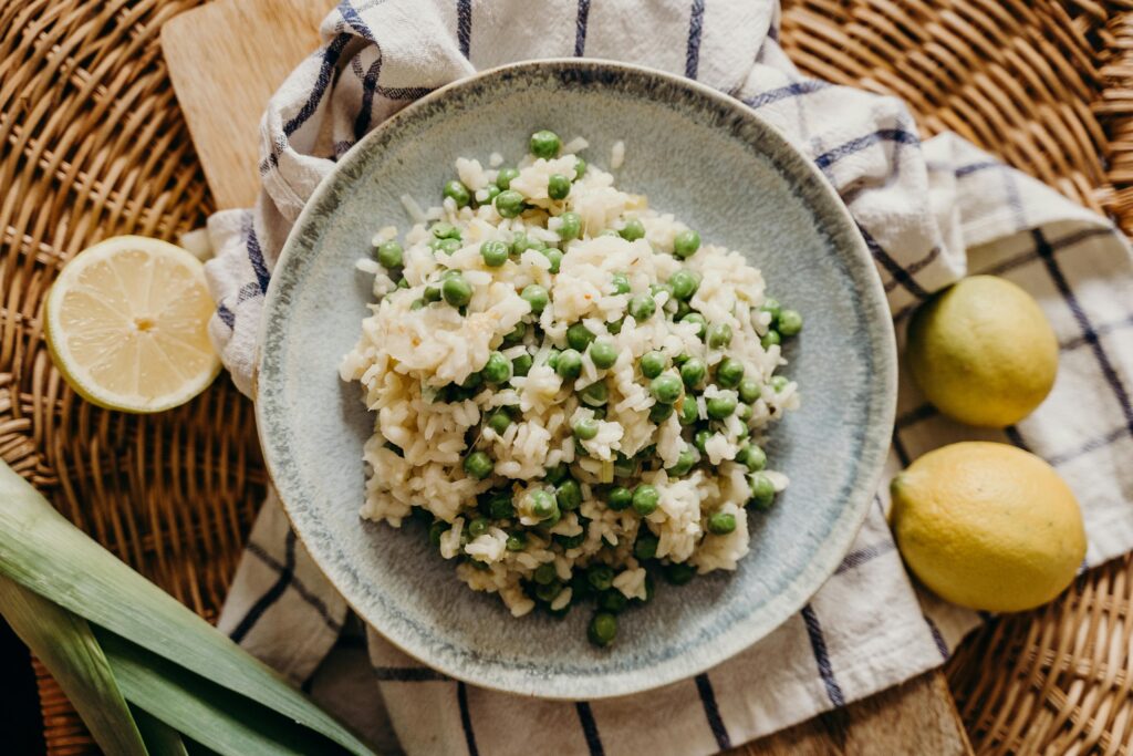 Erbsenrisotto mit Minze und geriebenem Parmesan anrichten
