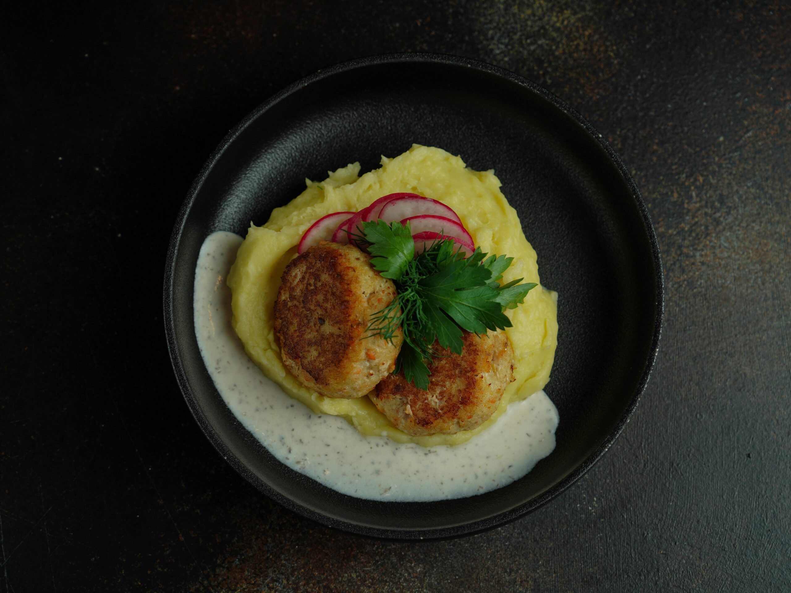 Wie macht man deftige Frikadellen mit Kartoffelpüree und Soße?