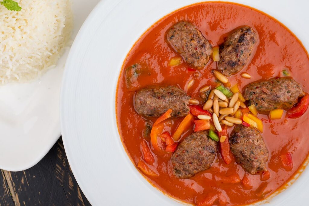 Wie macht man würzige Hackbällchen in Tomatensoße mit Reis?