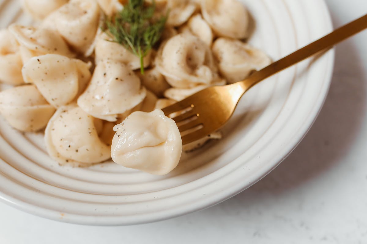 Wie macht man wuerzige Tortellini mit einer leichten Pesto Sahne Sosse
